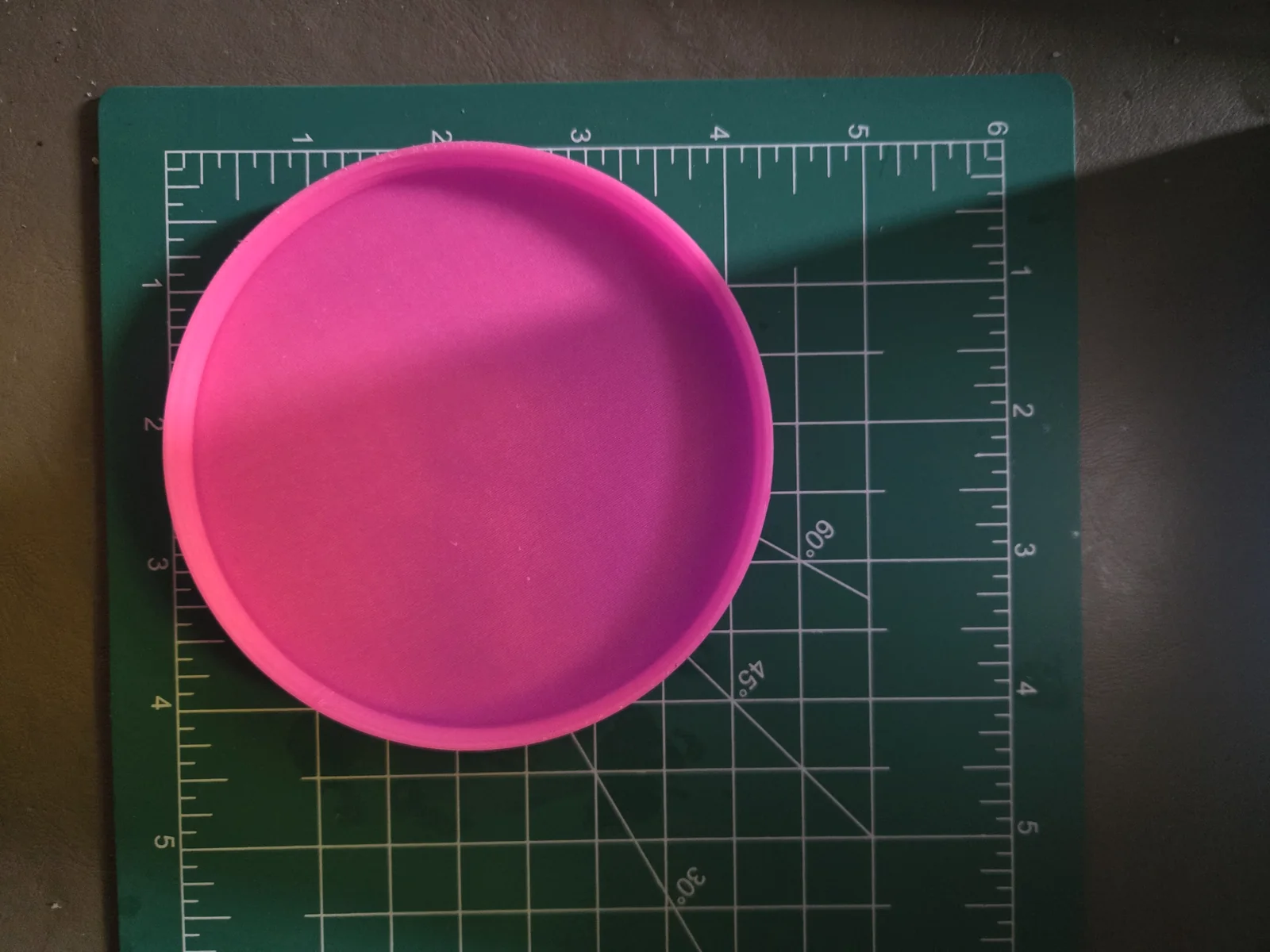 The container resting on a cutting mat marked in inches