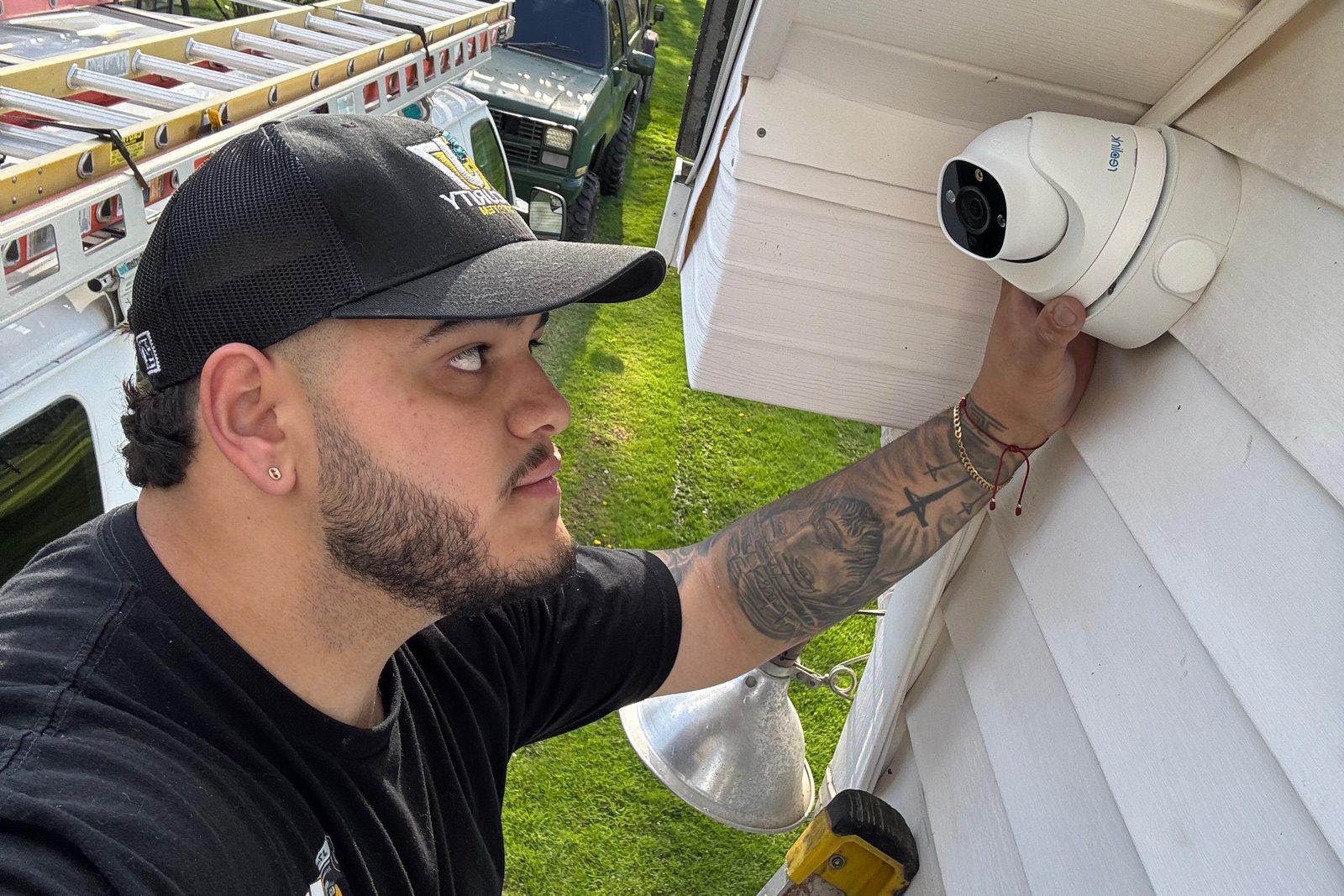 NexVision Labs technician mounting a turret camera under the eave of a home